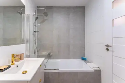 a bathroom with a tub and a sink and a shower at Rakowicka Superior Studio by BookingHost in Kraków