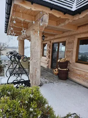 a bench in front of a log cabin at Babi czas in Podsarnie