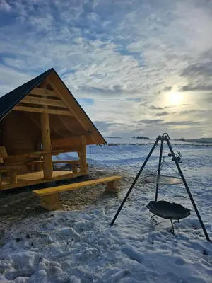 a wooden hut with a swing in the snow at Babi czas in Podsarnie