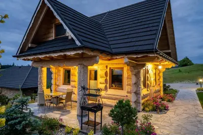 a log home with a black roof at Babi czas in Podsarnie