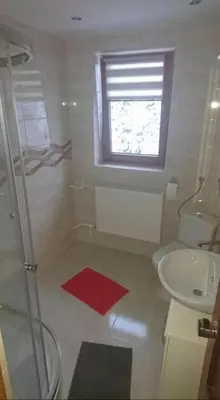 a bathroom with a sink and a toilet and a window at Noclegi KLARA in Zawoja