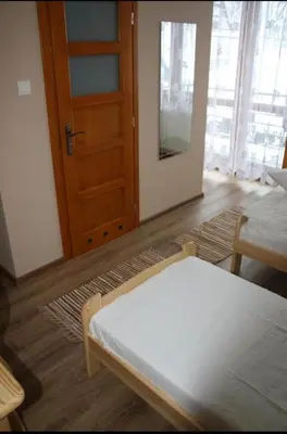 a room with a bed and a wooden door at Noclegi KLARA in Zawoja