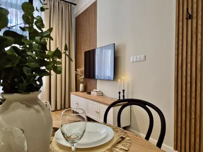 a living room with a table and a mirror at Wawel Square Residence in Kraków
