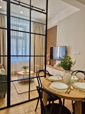 a bedroom with a bed and a desk and a potted tree at Wawel Square Residence in Kraków