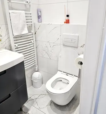 a white bathroom with a toilet and a sink at Juwel Apartments z widokiem na Wawel 32 in Kraków