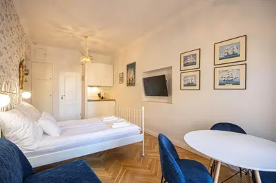 a room with a bed and a table and chairs at Plac Matejki Apartments by Noah in Kraków