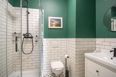 a green and white bathroom with a shower and a toilet at Plac Matejki Apartments by Noah in Kraków