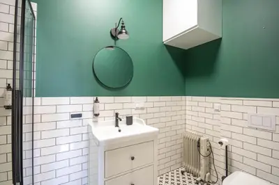 a green bathroom with a sink and a mirror at Plac Matejki Apartments by Noah in Kraków