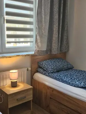 a small bedroom with a bed and a window at Grey Apartment in Kraków