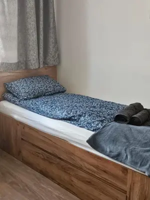 a bedroom with a bed with a wooden frame at Grey Apartment in Kraków