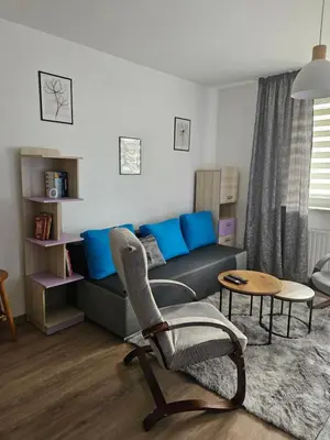 a living room with a couch and a chair at Grey Apartment in Kraków