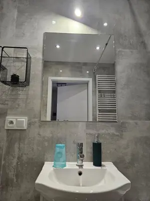 a bathroom with a sink and a mirror at Grey Apartment in Kraków