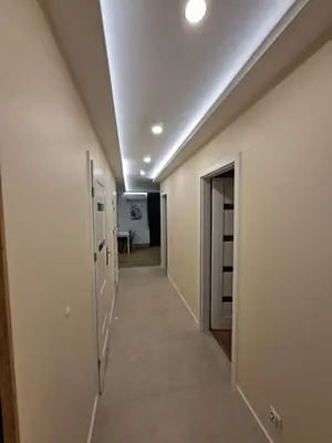 a hallway with white walls and a ceiling at Apartament Rydlówka 39 in Kraków