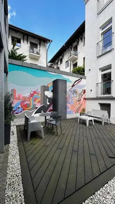 a patio with benches and a mural on the side of a building at Różana Near Wawel Castle in Kraków