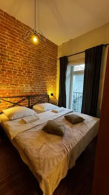 a large bed in a room with a brick wall at Różana Near Wawel Castle in Kraków