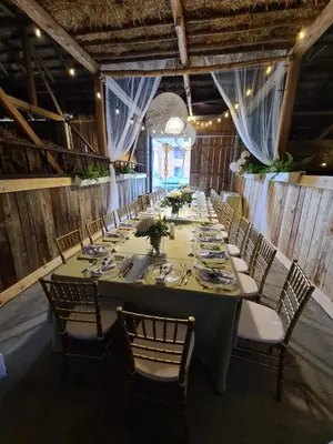 a long dining room with a long table and chairs at Dom w zaciszu stodoły