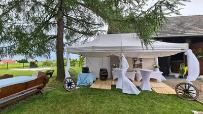 a white gazebo with tables and chairs in a yard at Dom w zaciszu stodoły