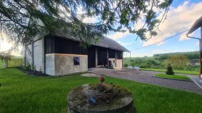 a building with a bird sitting on top of a yard at Dom w zaciszu stodoły