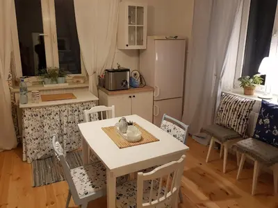 a kitchen with a white table and chairs and a kitchen with a refrigerator at Dom w zaciszu stodoły
