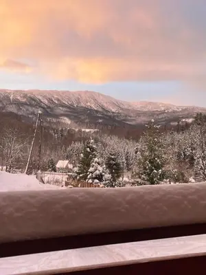 a view of a snowy mountain from a window at Arkadia pod Diablakiem in Zawoja