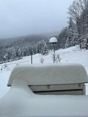 a bench covered in snow in front of a fence at Arkadia pod Diablakiem in Zawoja