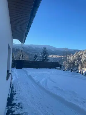 a snow covered road with mountains in the background at Arkadia pod Diablakiem in Zawoja