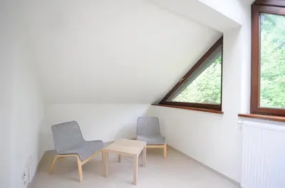 two chairs and a table in a room with a window at Dom Pielgrzyma KARMEL in Krzeszowice