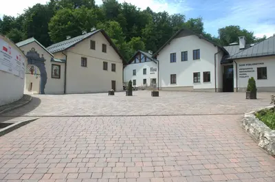 a row of white buildings on a brick driveway at Dom Pielgrzyma KARMEL in Krzeszowice