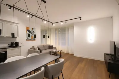 a bedroom with a bed with white sheets and pillows at Wawel Apartments by Noah in Kraków