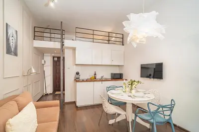 a living room and kitchen with a table and chairs at Grzegórzki Studio - Entresol, Top Location - by Rentujemy in Kraków