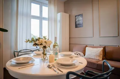 a table with plates and a bottle of wine on it at Grzegórzki Studio - Entresol, Top Location - by Rentujemy in Kraków