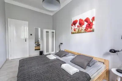 a bedroom with a bed and a painting on the wall at Fenna Apartments 7 minut od Rynku in Kraków