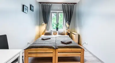 a room with two beds in front of a window at Fenna Apartments 7 minut od Rynku in Kraków