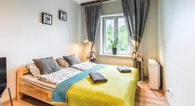 a bedroom with a large bed and a window at Fenna Apartments 7 minut od Rynku in Kraków