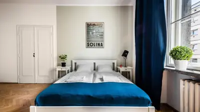 a bedroom with a blue bed and a window at Fenna Apartments 7 minut od Rynku in Kraków