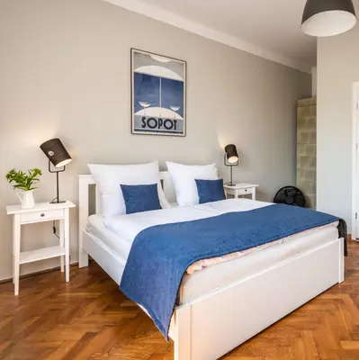 a bedroom with a large white bed with blue sheets at Fenna Apartments 7 minut od Rynku in Kraków