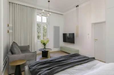 a bedroom with a bed and a chair and a tv at Wawel View I Koletek 17 in Kraków