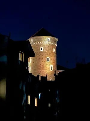 a large brick tower on top of a building at night at Wawel View I Koletek 17 in Kraków