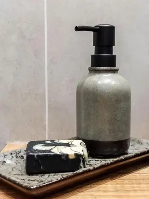 a bottle of soap sitting on a tray with a block of cheese at Meiselsa Apartments by Noah in Kraków