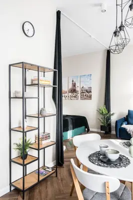a living room with a table and a book shelf at Meiselsa Apartments by Noah in Kraków
