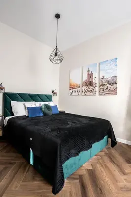 a bedroom with a bed with black sheets and blue pillows at Meiselsa Apartments by Noah in Kraków