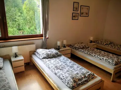 three beds in a room with a large window at Kwatery pracownicze Kęty Zielona in Kęty