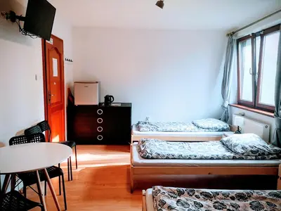 a room with two beds and a table in it at Kwatery pracownicze Kęty Zielona in Kęty