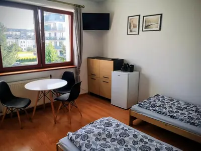a room with a bed and a table and a window at Kwatery pracownicze Kęty Zielona in Kęty