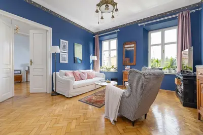 a living room with blue walls and a white couch at Uroczy Przestronny Apartament w Krakowie by Noclegi Renters in Kraków