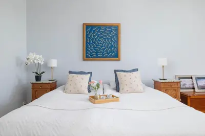a bedroom with a white bed with a tray of flowers on it at Uroczy Przestronny Apartament w Krakowie by Noclegi Renters in Kraków
