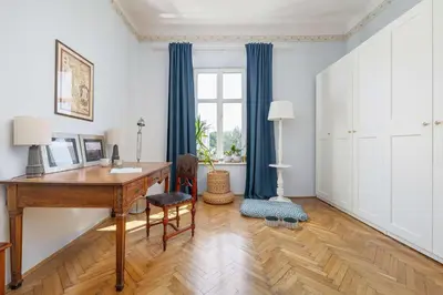 an office with a wooden desk and blue curtains at Uroczy Przestronny Apartament w Krakowie by Noclegi Renters in Kraków