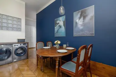 a dining room with a table and a washing machine at Uroczy Przestronny Apartament w Krakowie by Noclegi Renters in Kraków