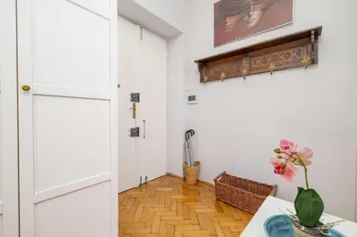 a room with a white door and a table with a vase at Uroczy Przestronny Apartament w Krakowie by Noclegi Renters in Kraków