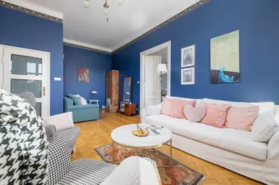 a living room with blue walls and a white couch at Uroczy Przestronny Apartament w Krakowie by Noclegi Renters in Kraków
